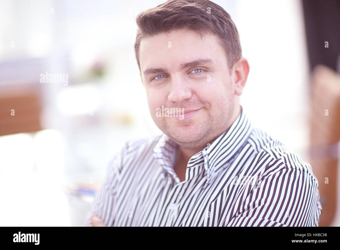 Successful young businessman posing and smiling at camera Stock Photo ...