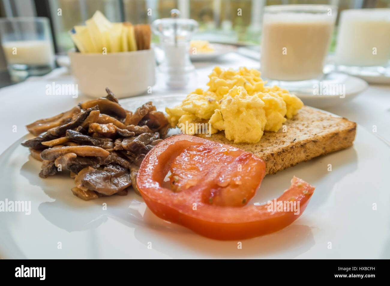 Breakfast with tomato, mushroom, scramble eggs on toast Stock Photo