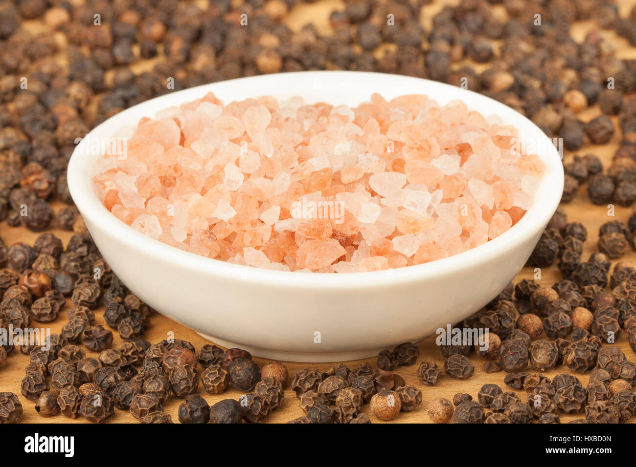 Scattered black peppercorn base with Himalayan sea salt contrast Stock Photo