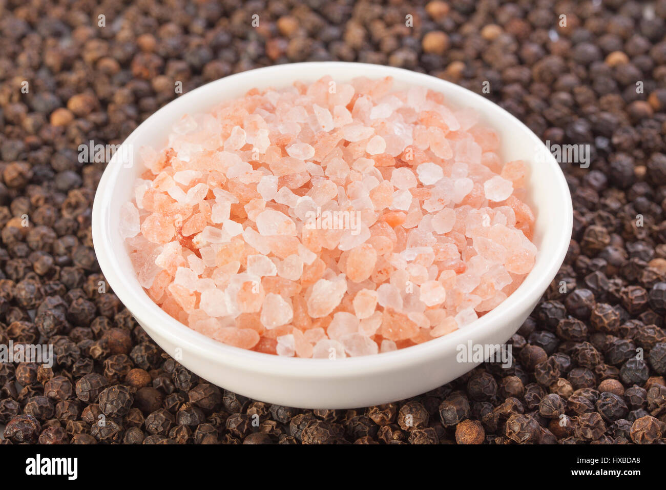 Black peppercorn base with Himalayan sea salt contrast Stock Photo