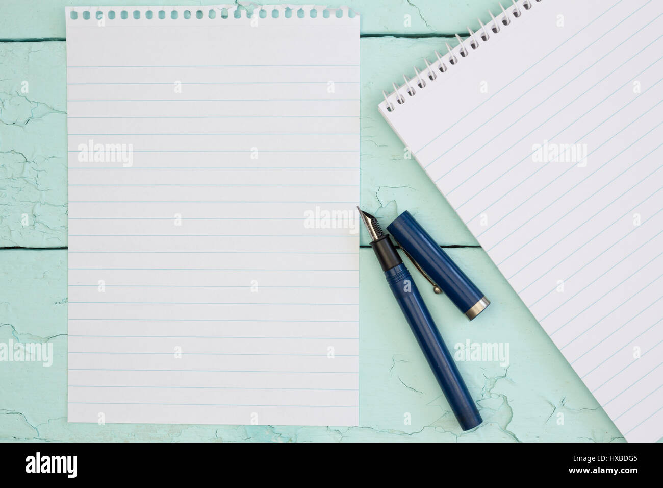 Blank note pad paper and fountain pen with ringbinder note pad on blue