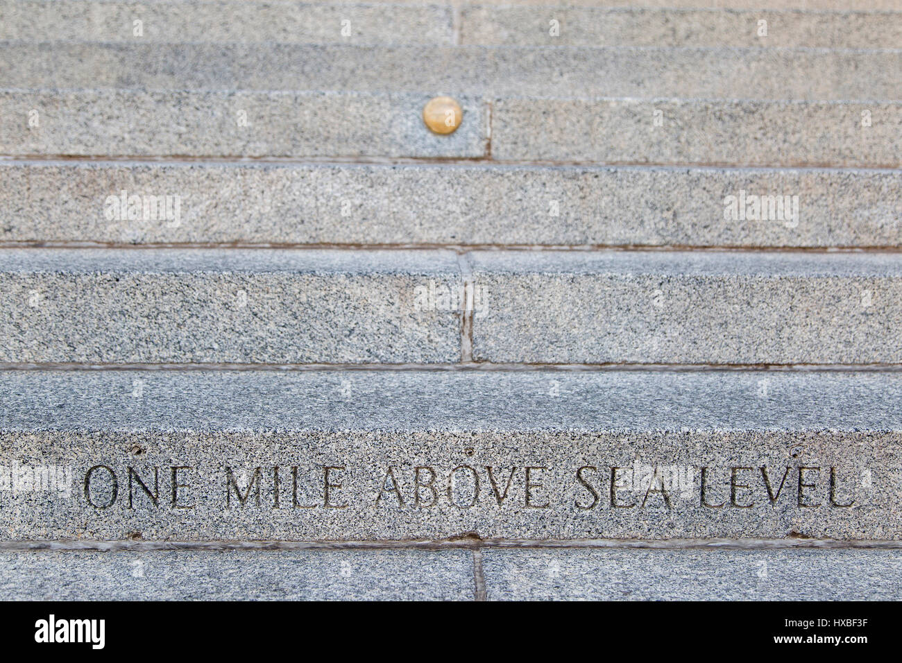 An inscription and gold marker on the steps of the Denver state capital building designate the one mile above sea level altitude in Denver, Colorado Stock Photo
