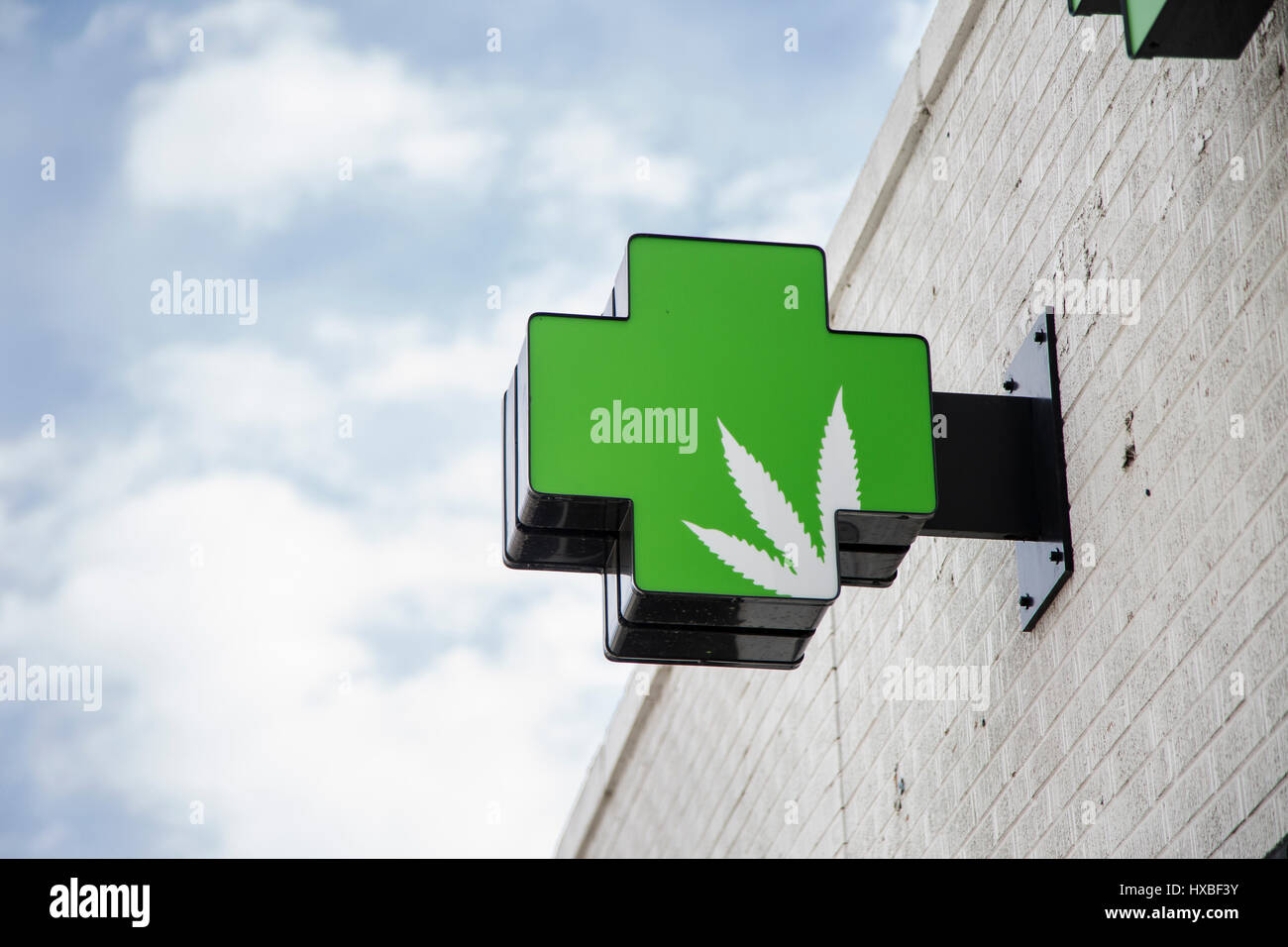 A medical green cross marijuana sign on the exterior of a dispensary in