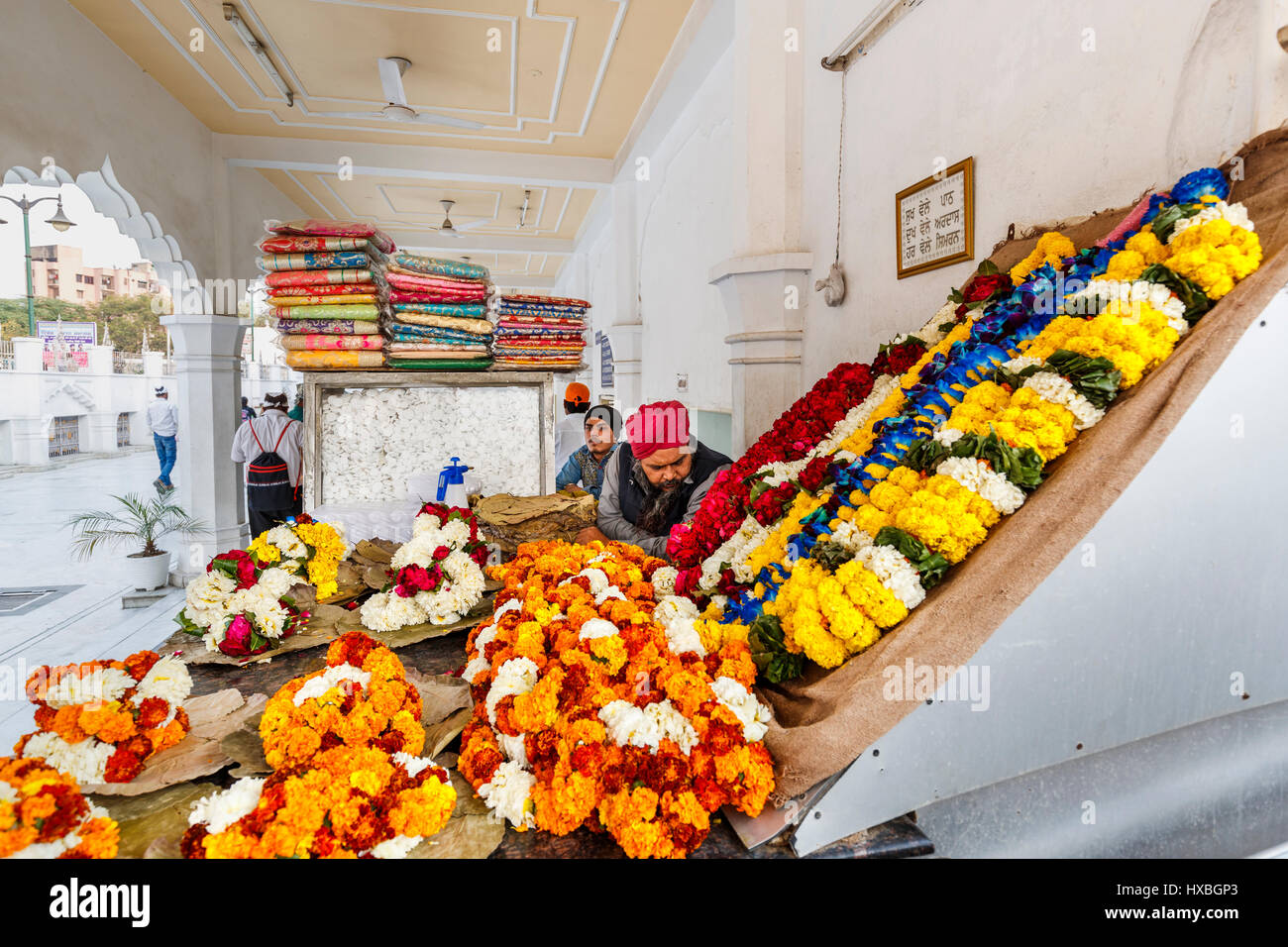 Volunteers selling marigolds as votive offerings at Gurudwara Bangla