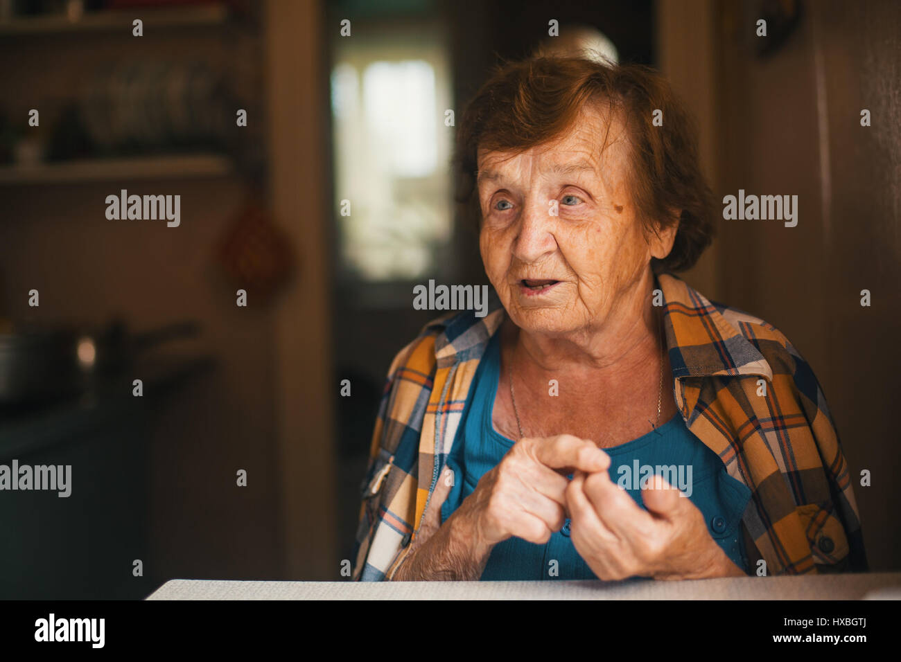 Portrait of an old woman at a table Stock Photo - Alamy