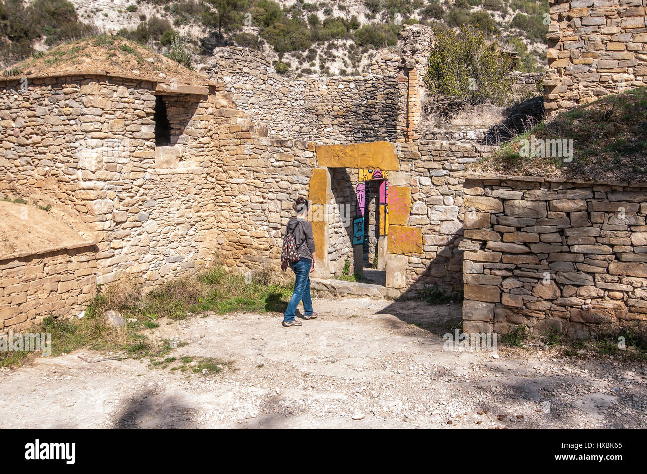 Woman entering an abandoned stone house Stock Photo - Alamy