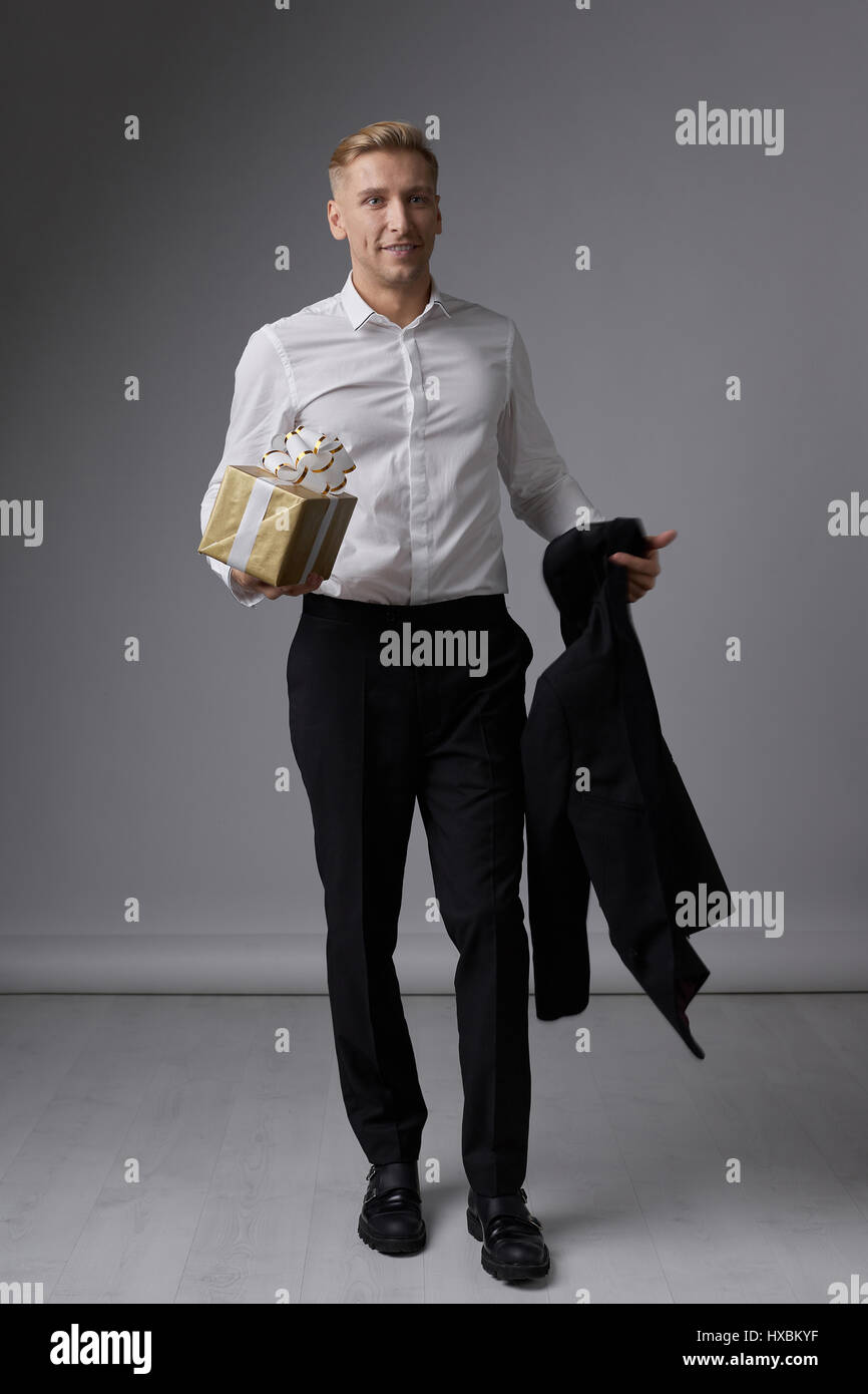 Portrait of a handsome young man smiling against gray background ...