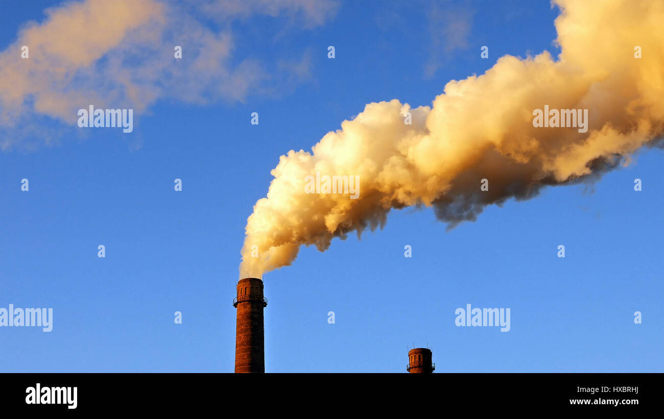 Factory plant smoke stack over blue sky background Stock Photo - Alamy