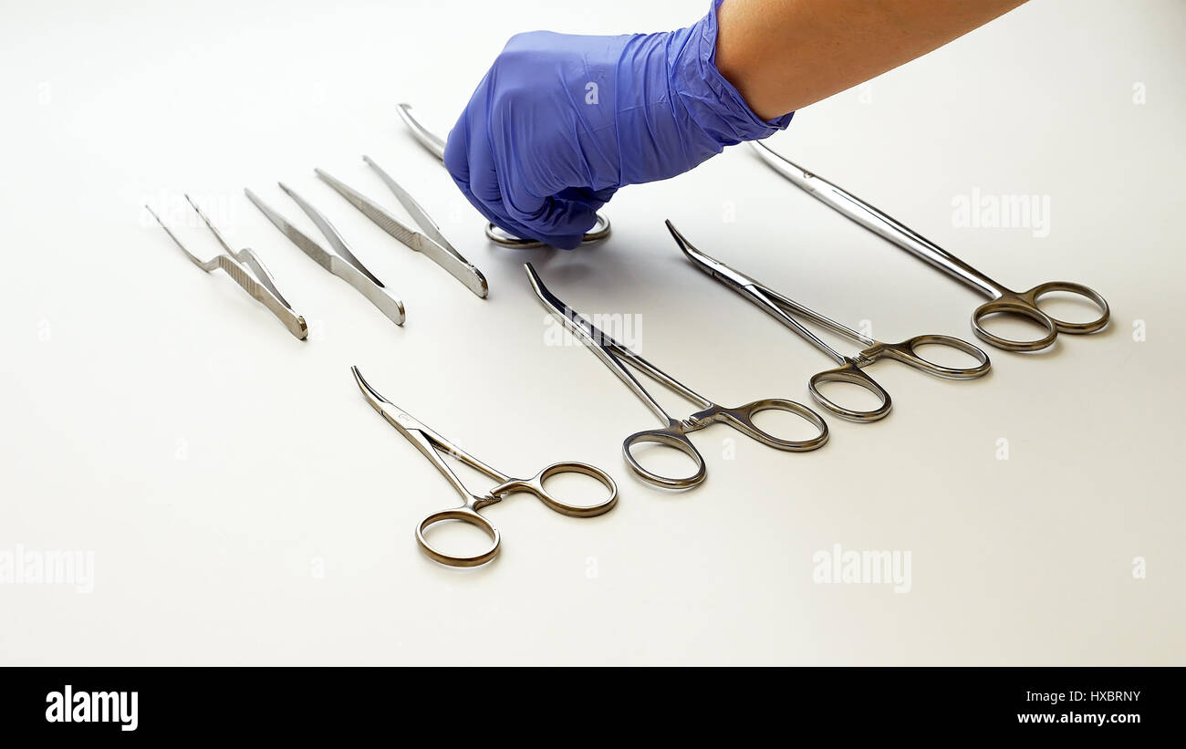 Surgical nurse puts medical surgery tools on table Stock Photo