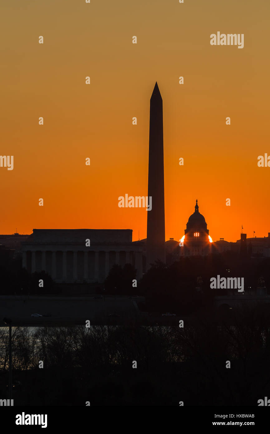 The sun rises behind the US Capitol Building near the spring equinox in Washington, DC. Stock Photo
