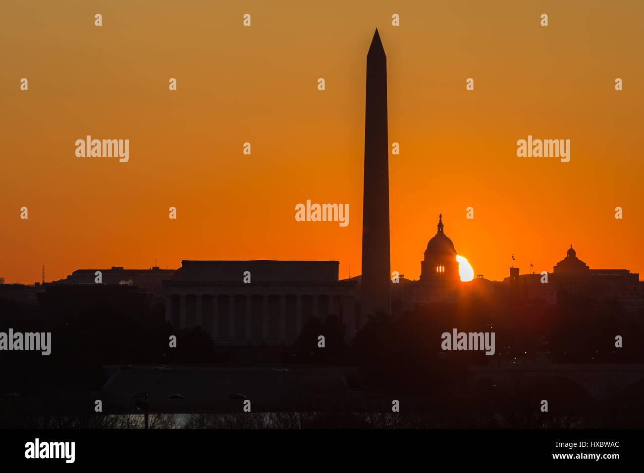 The sun rises behind the US Capitol Building near the spring equinox in Washington, DC. Stock Photo