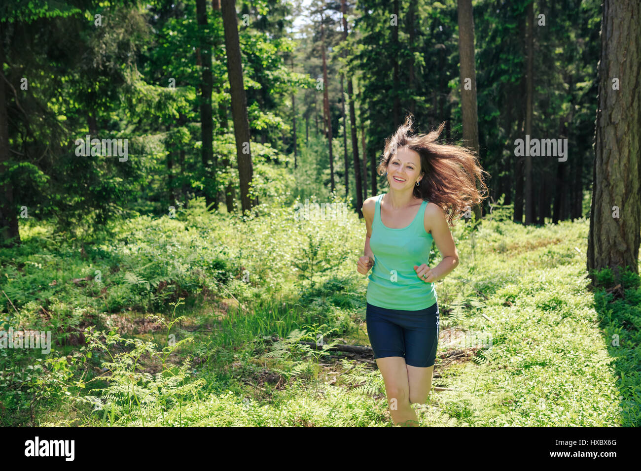 young woman jogging in a forest Stock Photo - Alamy