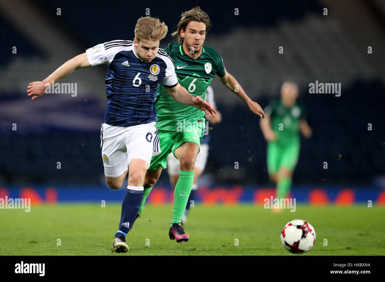 Scotland's Stuart Armstrong (left) and Slovenia's Rene Krhin battle for the ball during the World Cup Qualifying match at Hampden Park, Glasgow. Stock Photo