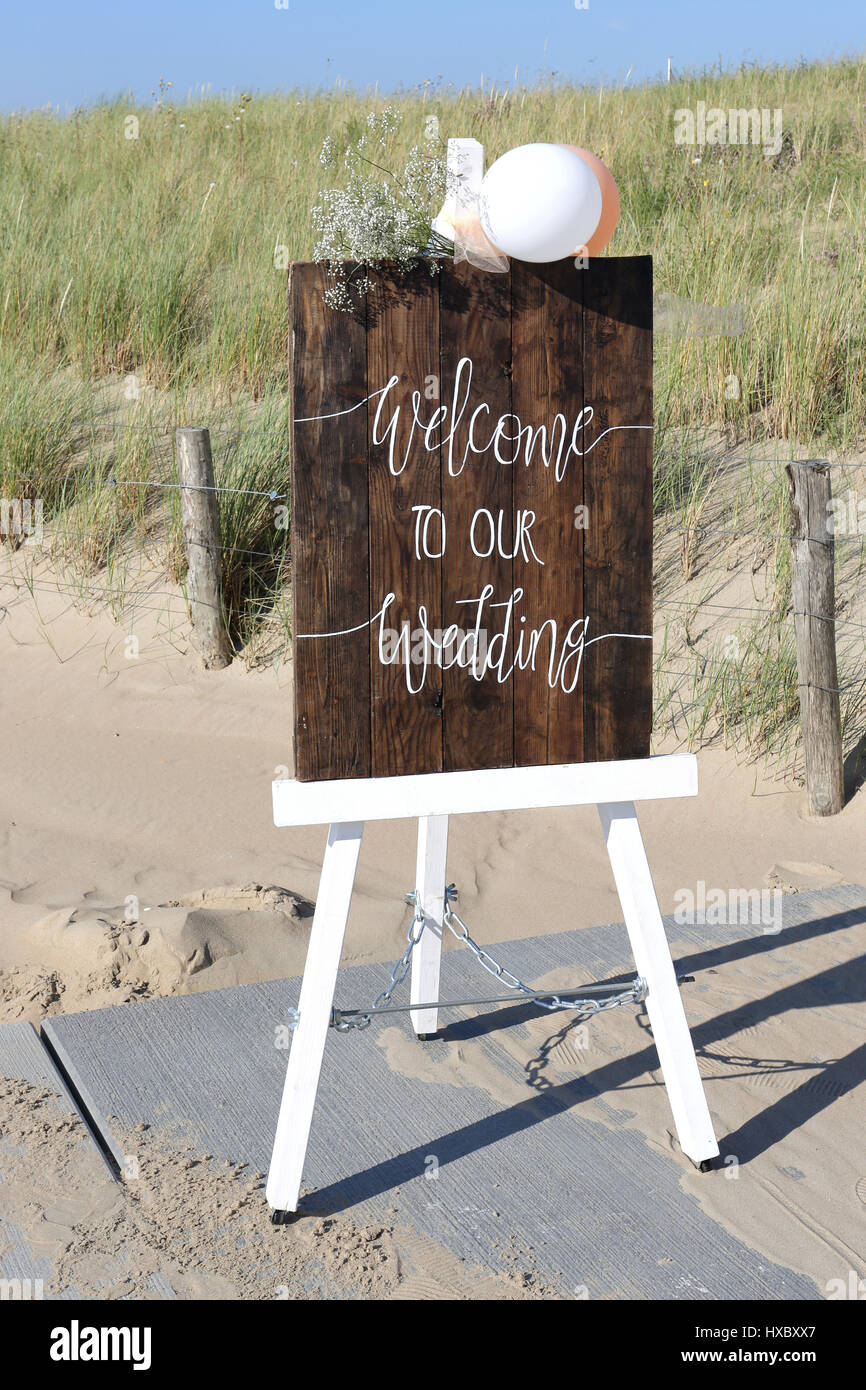 easel with wooden WELCOME TO OUR WEDDING sign in front of dunes Stock Photo  - Alamy
