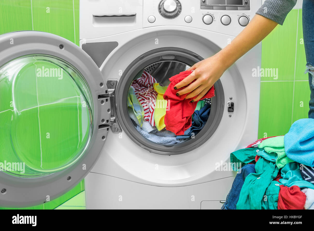 Preparing the wash cycle. Washing machine, hands and clothes Stock