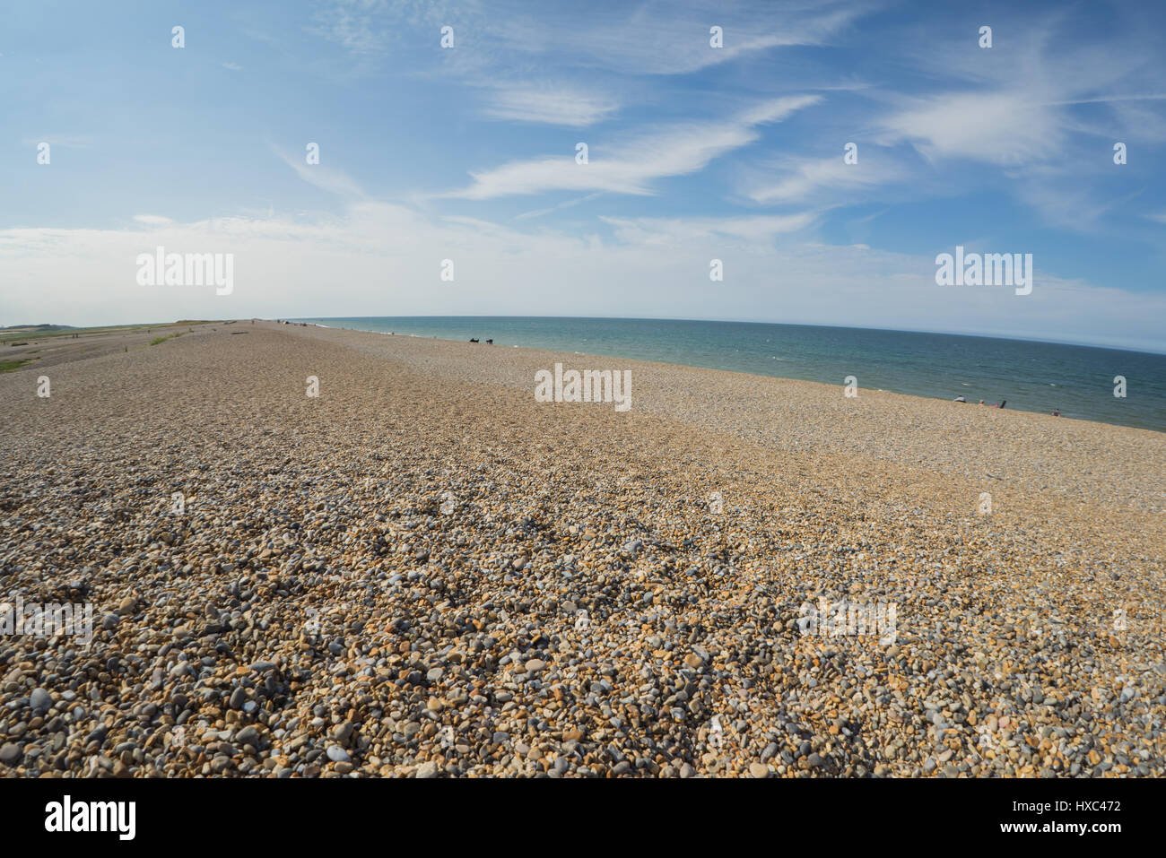 Norfolk coastline on the beech, pebbles with grasland, blue sky white clouds Stock Photo