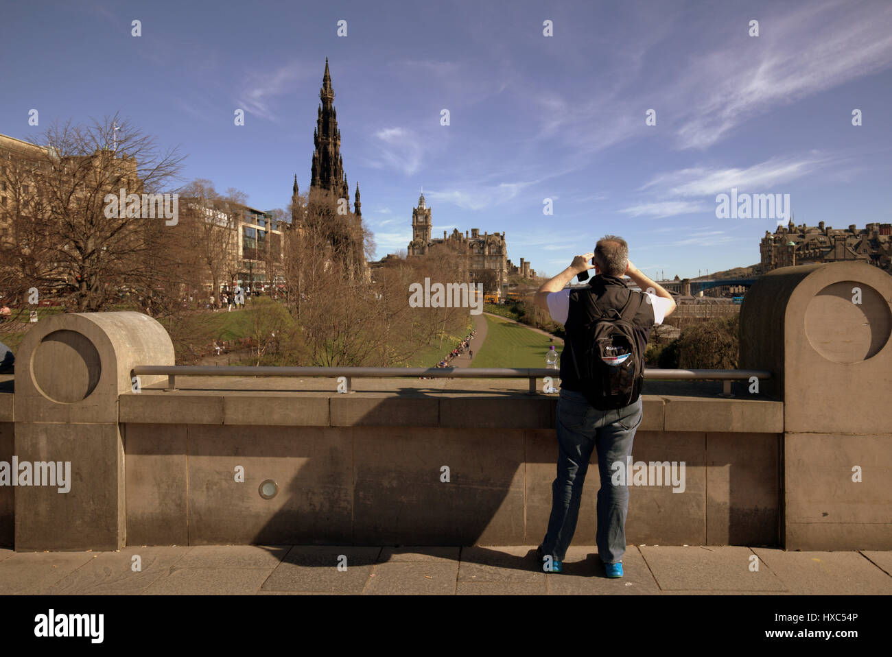 Tourists in princes street gardens at the National Museum of Scotland take selfies selfie selfy selfie with Edinburgh panorama as a backdrop Stock Photo