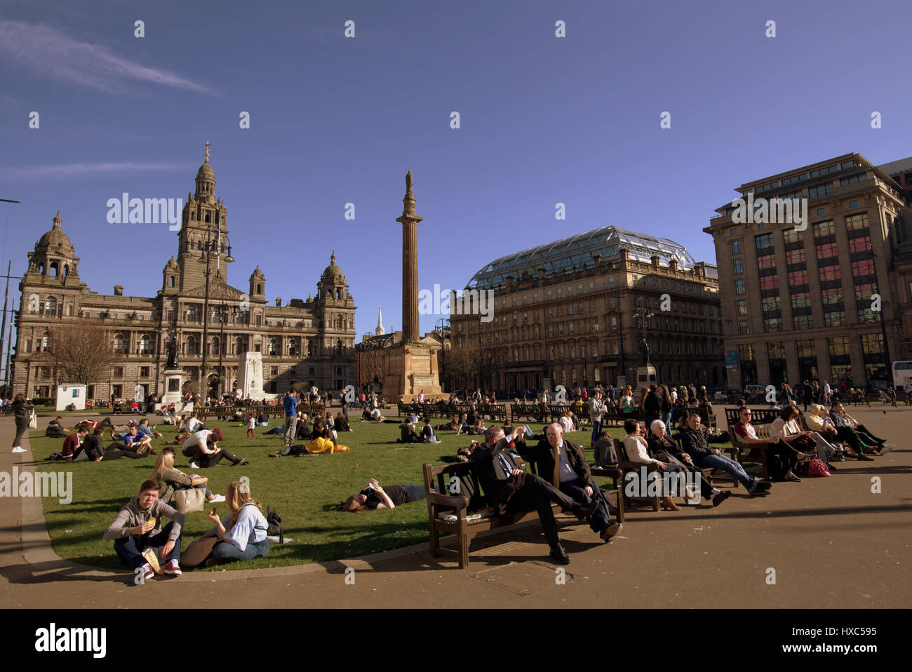 George Square in the city centre filld with ditizenx and tourists enjoying the unseasonable sunshine Stock Photo
