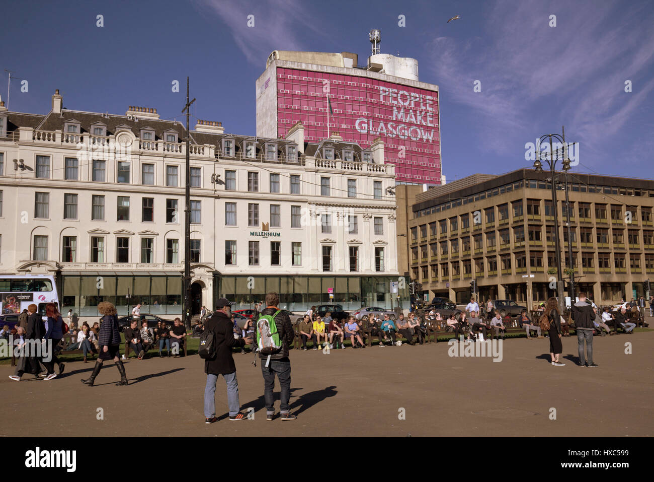 George Square in the city centre filld with ditizenx and tourists enjoying the unseasonable sunshine Stock Photo