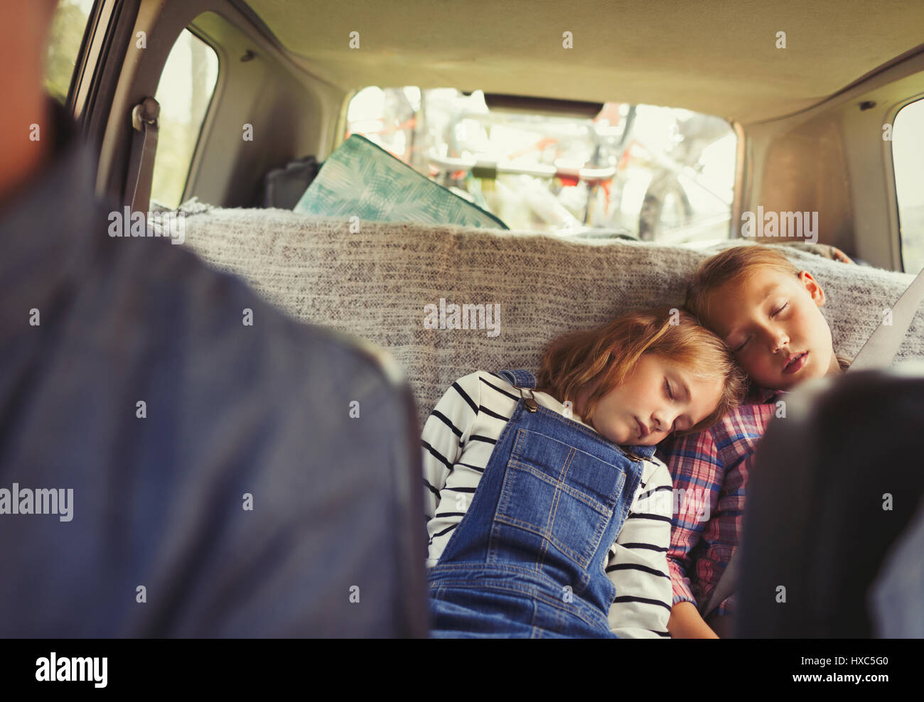 Tired sisters sleeping in back seat of car Stock Photo