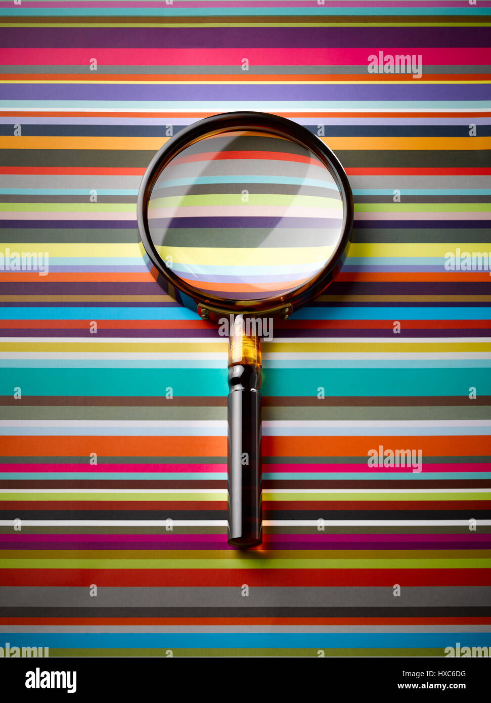 Magnifying glass on striped background Stock Photo