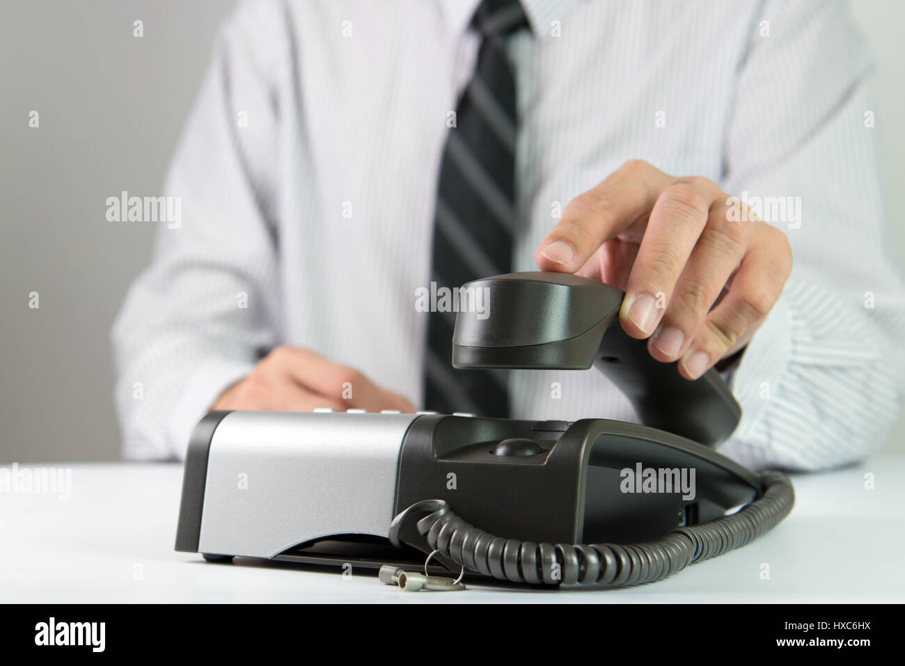 Close up of businessman picking up landline phone Stock Photo
