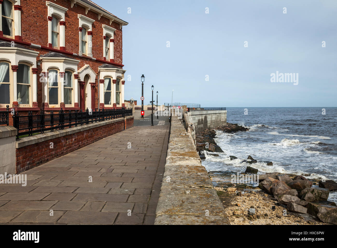 The seafront  and houses at Hartlepool Headland,England,UK, with the waves crashing against the rocks Stock Photo