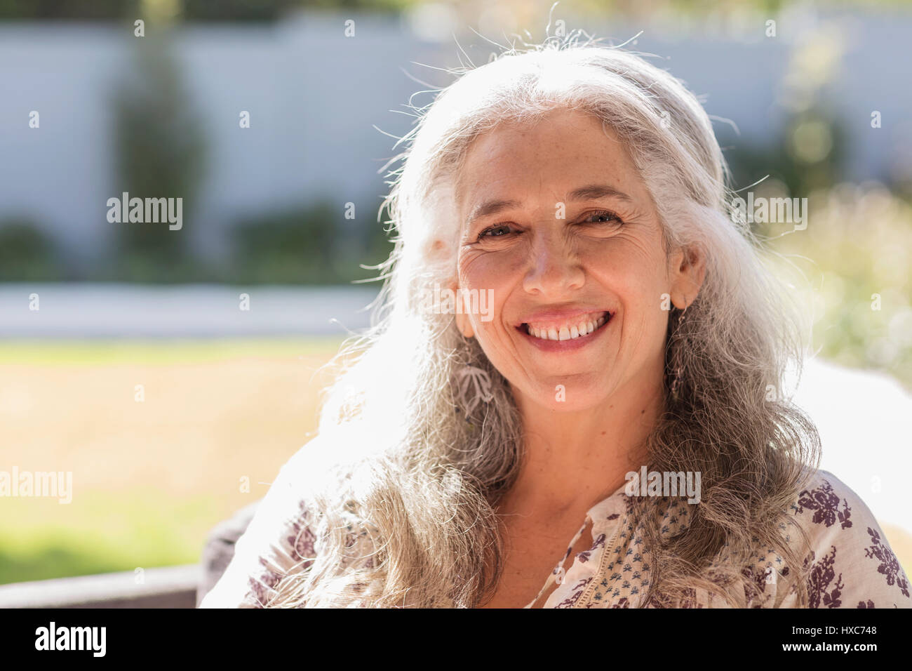 Portrait smiling mature woman in sunny garden Stock Photo - Alamy