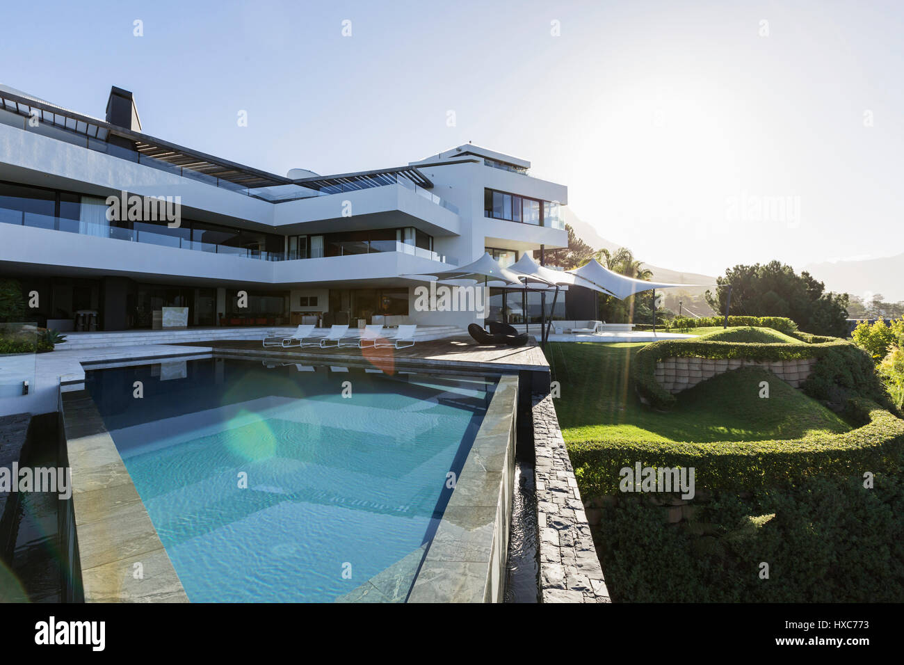 Sunny modern luxury home showcase exterior with infinity pool Stock ...