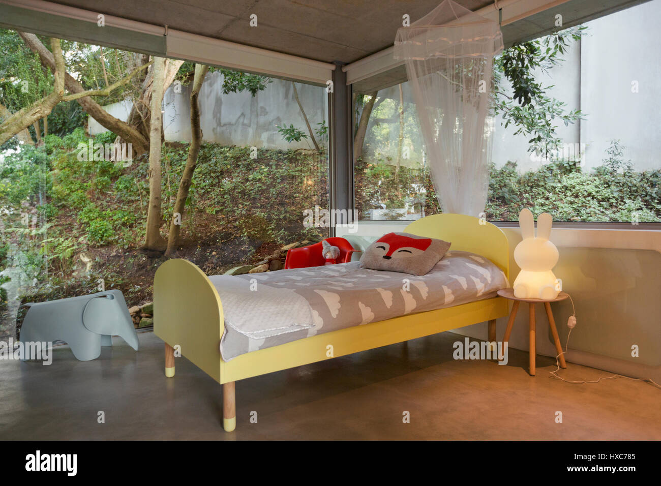 Modern luxury home showcase interior child’s bedroom surrounded by windows Stock Photo