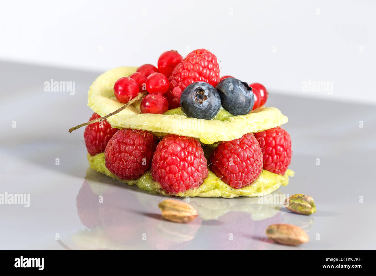 Fresh raspberry macaroon cake with custard and raspberry ,red berries, blueberries and currants Stock Photo