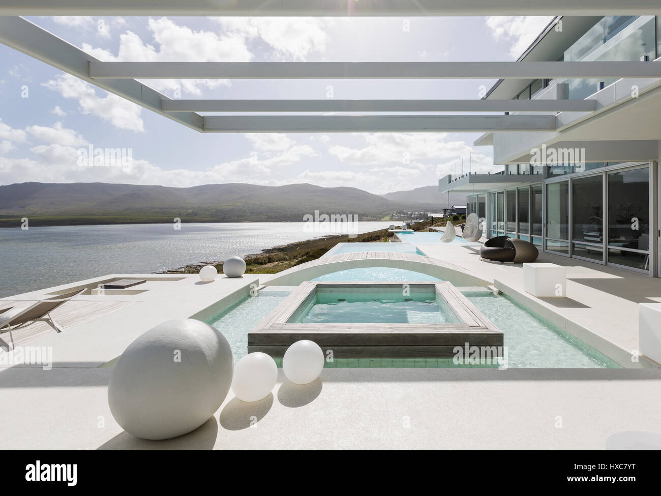 Sunny, tranquil modern luxury home showcase exterior with swimming pool ...