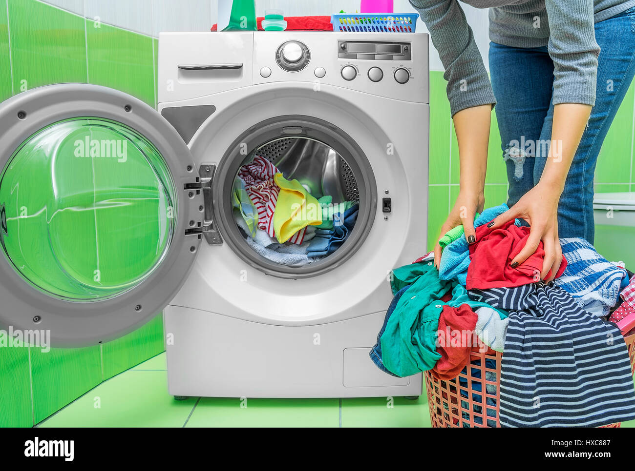 Preparing the wash cycle. Washing machine, hands and clothes Stock