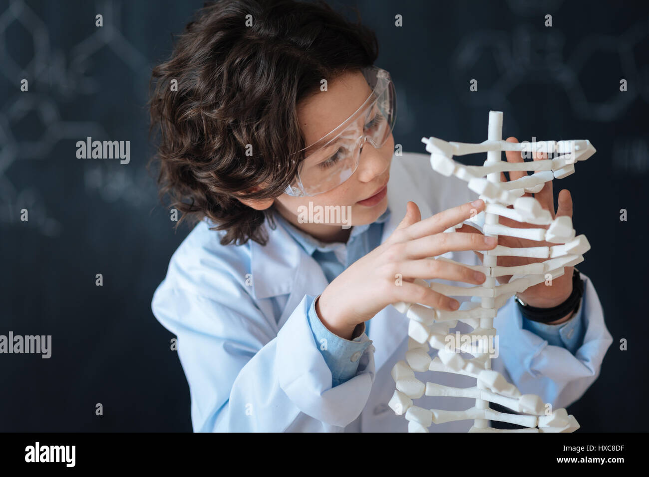 Involved boy enjoying chemistry project at school Stock Photo