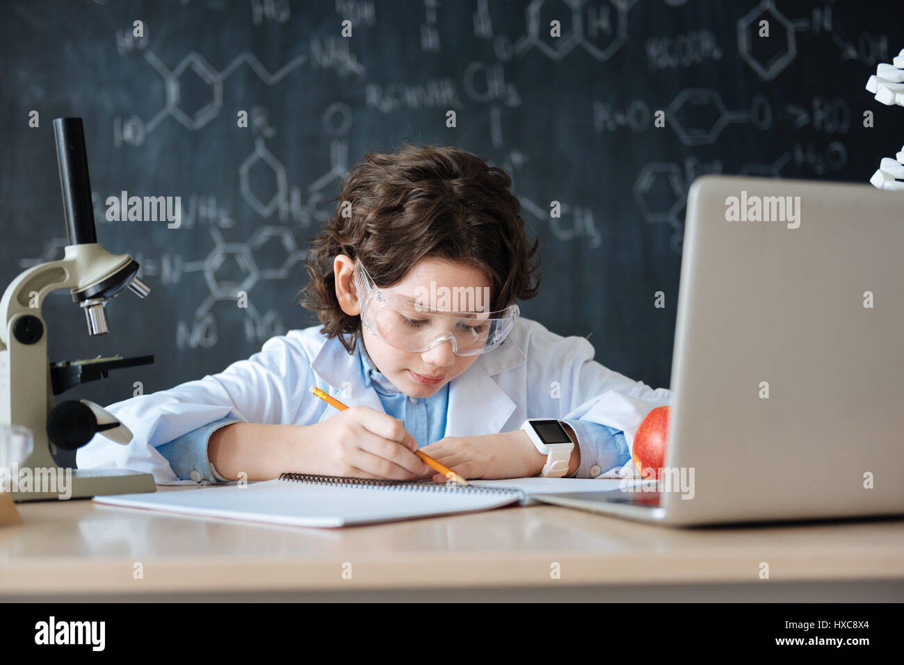 Attentive boy working on the science project in the laboratory Stock Photo