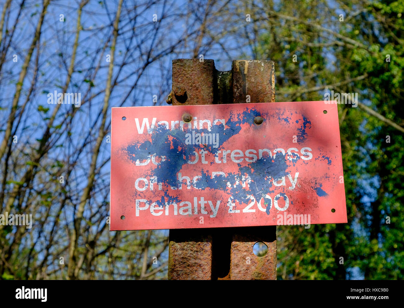 Red Railway trespass warning sign splattered with paint pictured in Bath,England,UK Stock Photo