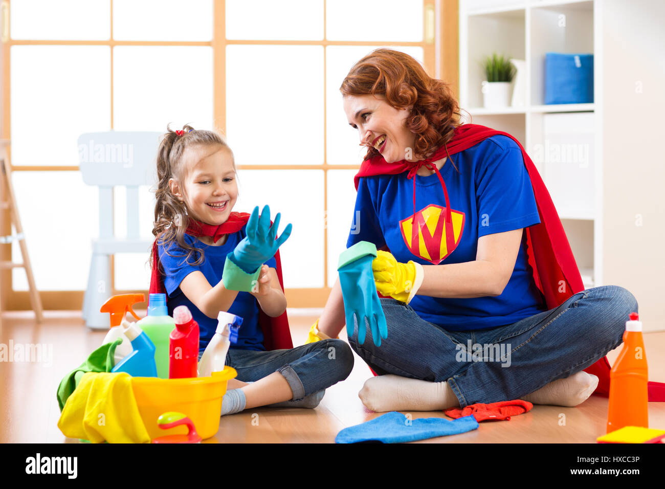 Child girl and her mother with cleaning supplies at home Stock Photo