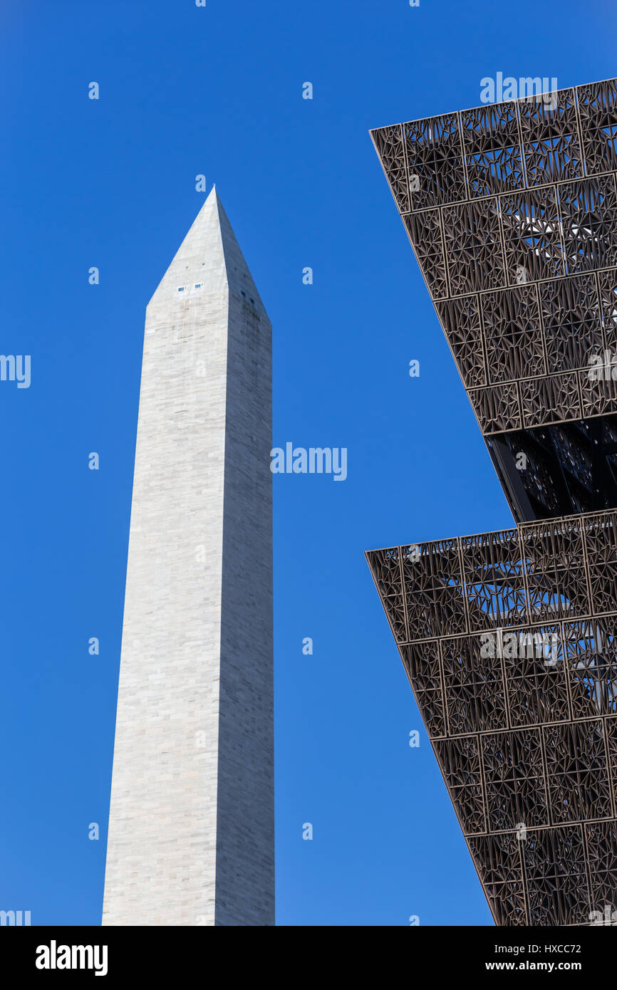 The angular metal architecture of the National Museum of African American History and Culture contrasts with the Washington Monument in Washington, DC Stock Photo