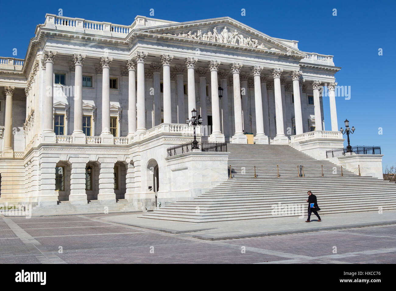 A man walks past the north wing (Senate wing) of the U.S. Capitol Building in Washington, DC. Stock Photo