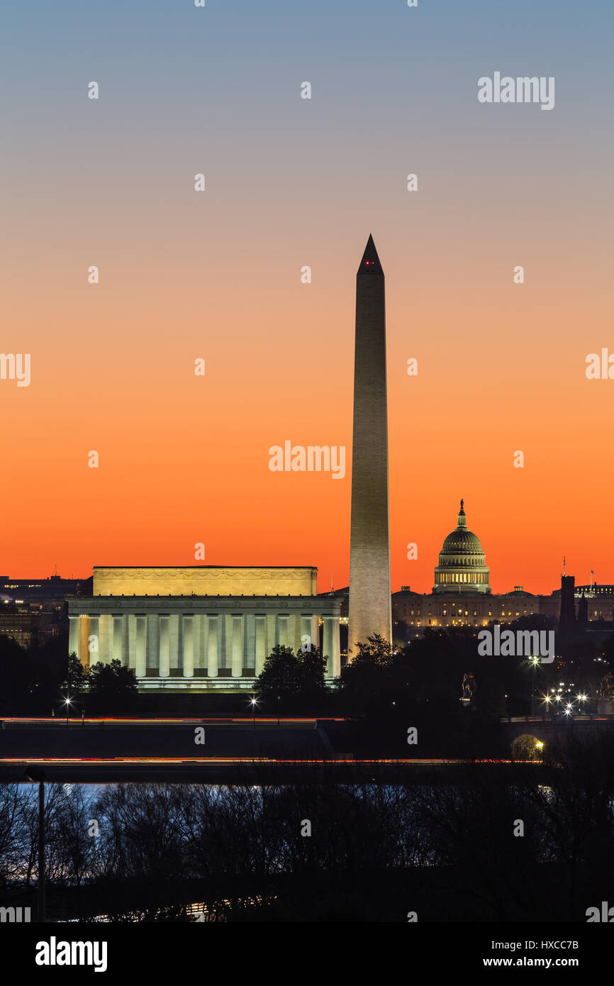 The Lincoln Memorial, Washington Monument, and US Capitol building set against an orange sky during morning twilight in Washington, DC. Stock Photo