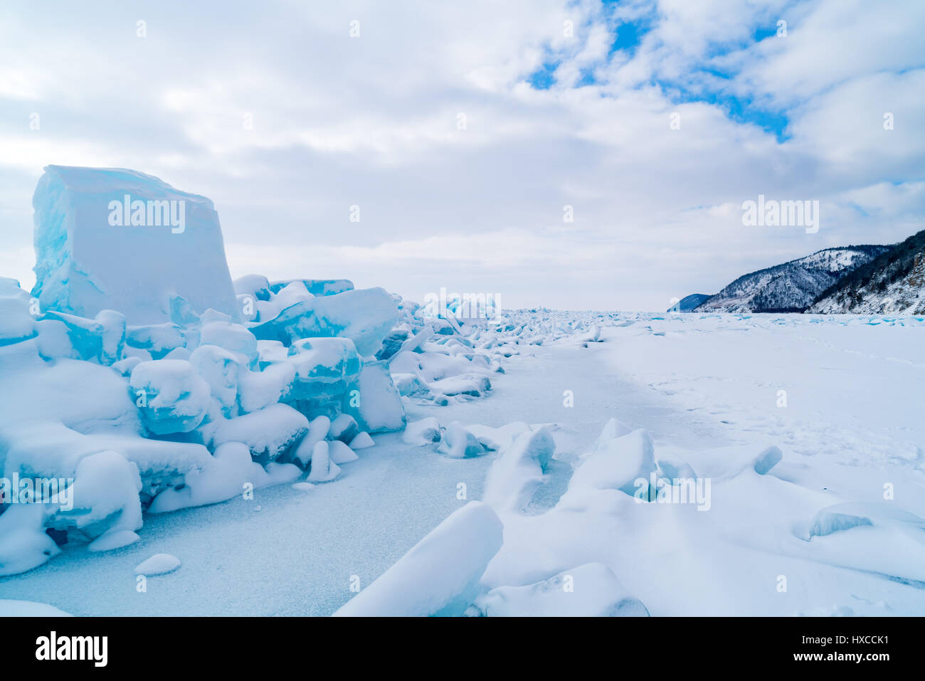 Row of ice blocks and the mountain covering with snow at lake Baikal in Russia in the winter Stock Photo