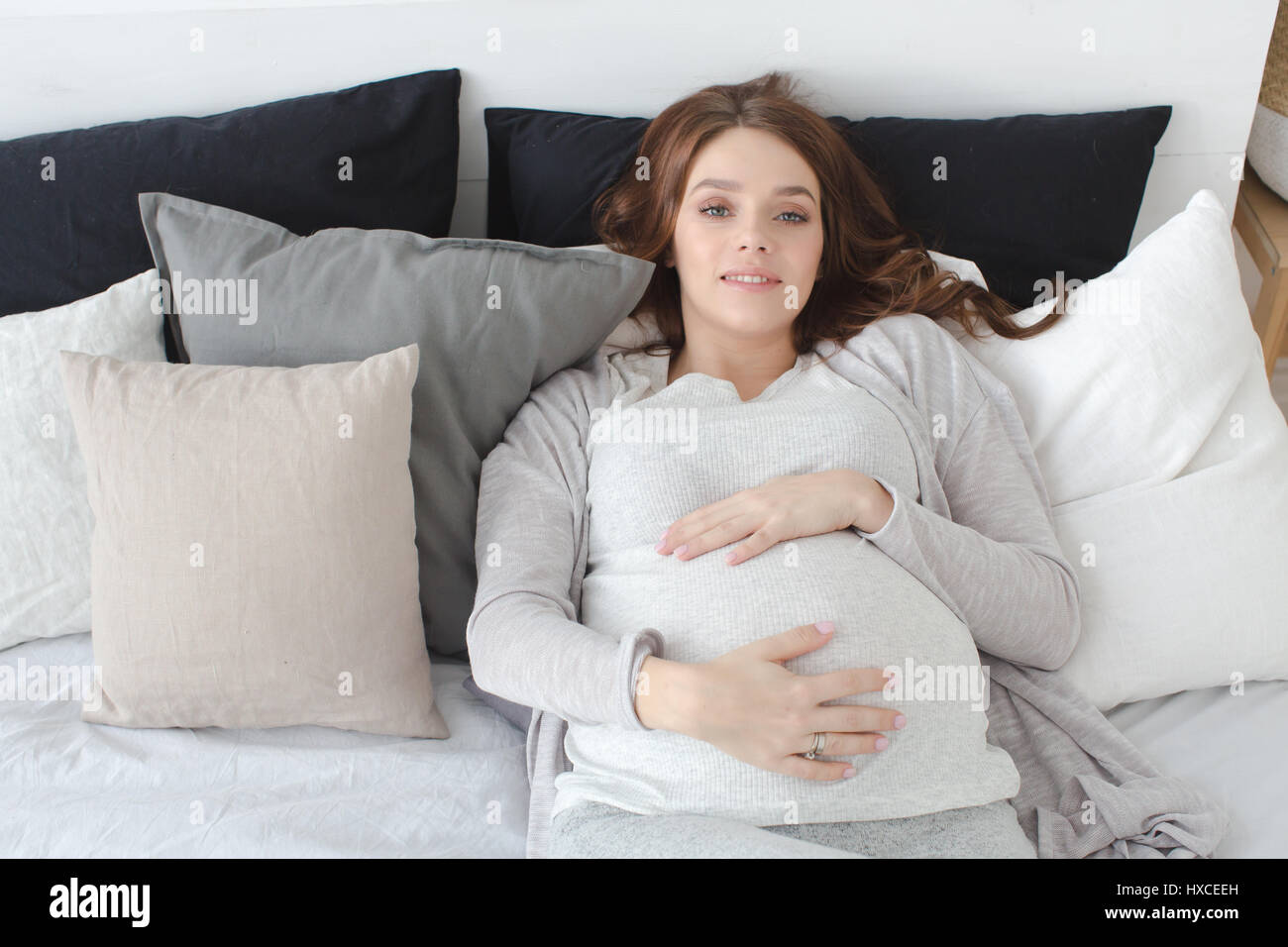 Pregnant female lying on a bed Stock Photo