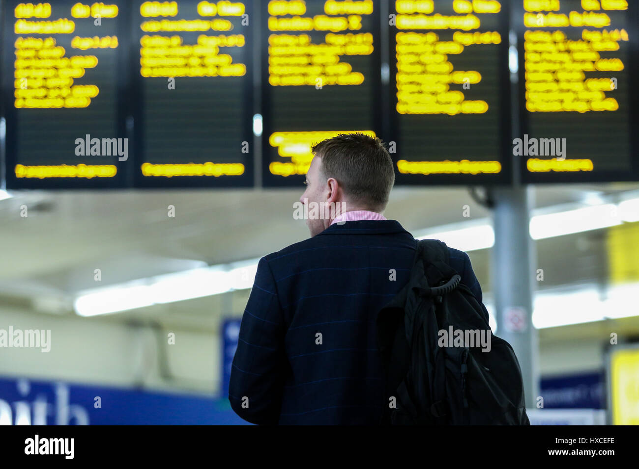 A man looks up at the Train timing screens at a train station in Yorkshire, England, UK. Stock Photo