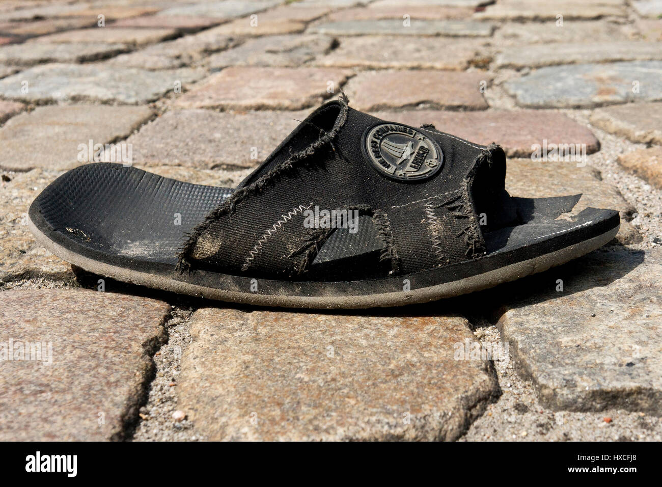 An old sandal lies on the street, In old sandal is on the road |, Eine alte Sandale liegt auf der Strasse |An old sandal is on the road| Stock Photo