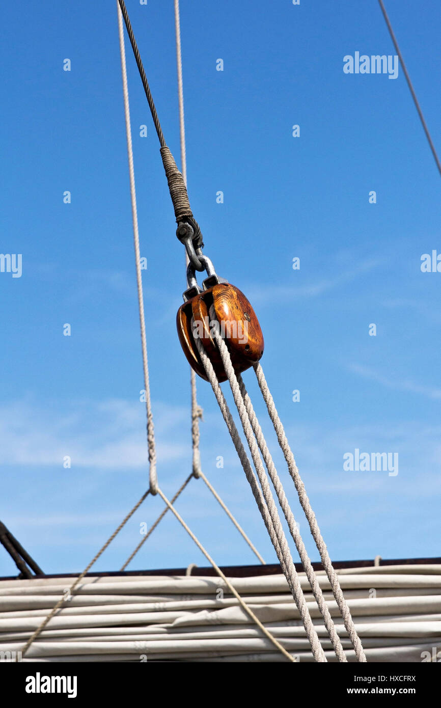 An Umlenkrolle of wood with rope's work on a traditional yachtsman, A wooden pulley with ropes on a sailing yacht |, Eine Umlenkrolle aus Holz mit Tau Stock Photo