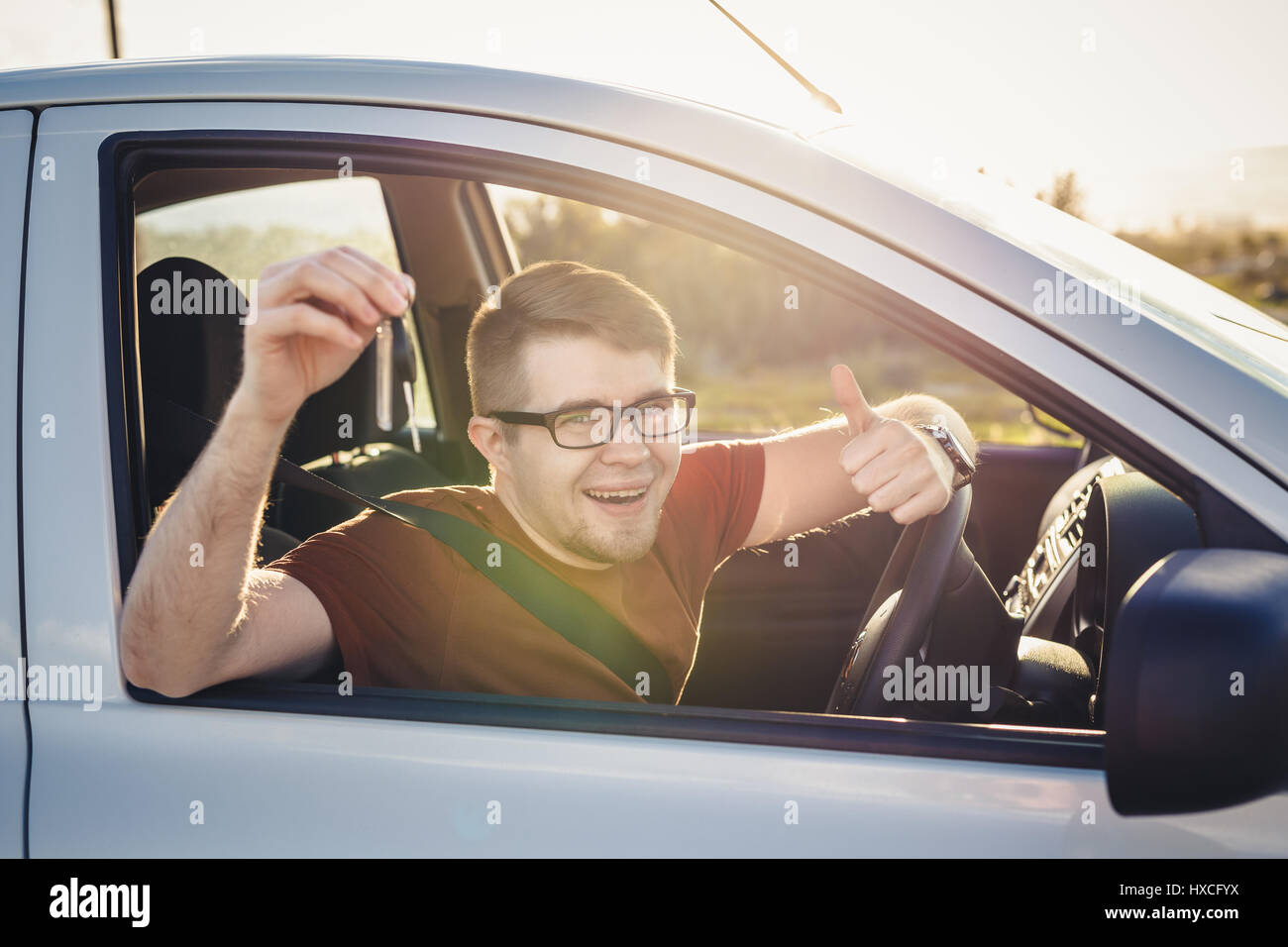 Attractive young man showing his new car keys and smiling Stock Photo ...