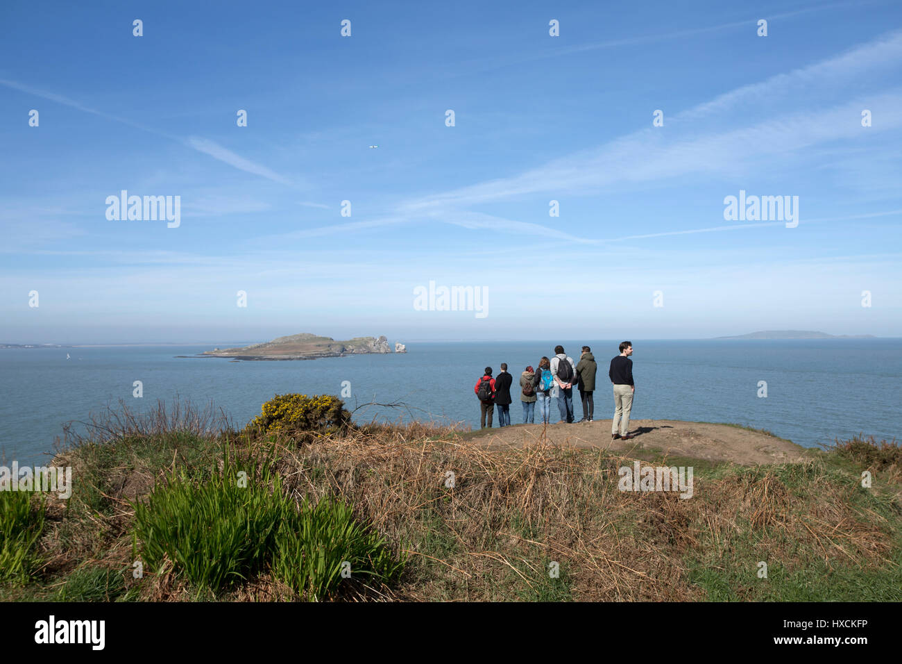 A group of tourists looking out over Dublin bay from Howth Head, Dublin city, Ireland. Stock Photo