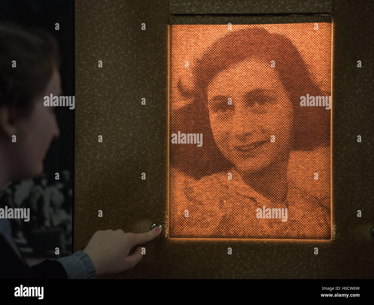 Frankfurt, Germany. 24th Mar, 2017. A visitor looks at the portrait of Anne Frank in an exhibition in Frankfurt, Germany, 24 March 2017. At the end of March this year the exhibition 'Anne Frank. A girl from Germany' at the Anne Frank Educational Centre will end after 14 years. In the future the story of Frank will be re-told with new methods. An interactive learning laboratory will be opened in the summer of 2018. Photo: Andreas Arnold/dpa/Alamy Live News Stock Photo