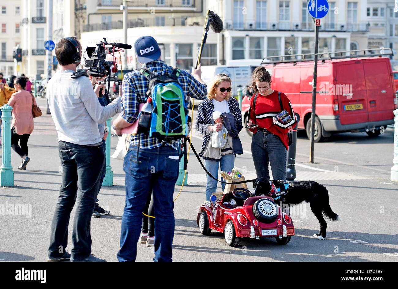 Brighton, UK. 27th Mar, 2017. Loki the dog drives his car along Brighton seafront this afternoon on another beautiful sunny day in the UK . Loki was being filmed for an ITV show to be aired later this summer Credit: Simon Dack/Alamy Live News Stock Photo