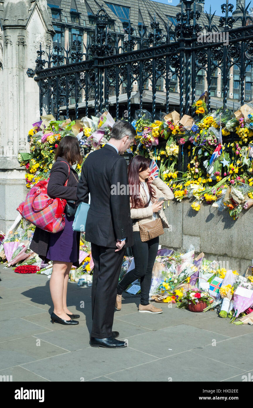 London, UK. 27th Mar, 2017. Jacob Rees-Mogg MP looks at the tributes. Parliament Square returns to normal except for a large police presence with large crowds outside the Houses of Parliament as the number of tributes after the terrorist attack grows. A car was driven into people on Westminster Bridge by Khalid Masood and a policeman Keith Palmer was killed. Credit: JOHNNY ARMSTEAD/Alamy Live News Stock Photo